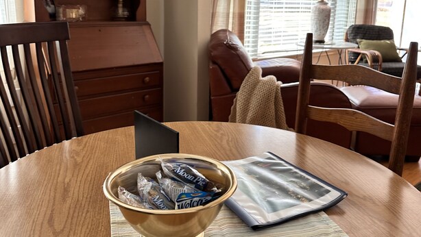 Un tavolo da pranzo con una ciotola di Moon Pie, una fotografia incorniciata e un portatile.