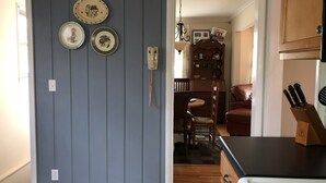 Cucina con un fornello, un armadietto di legno e un telefono fissato al muro.