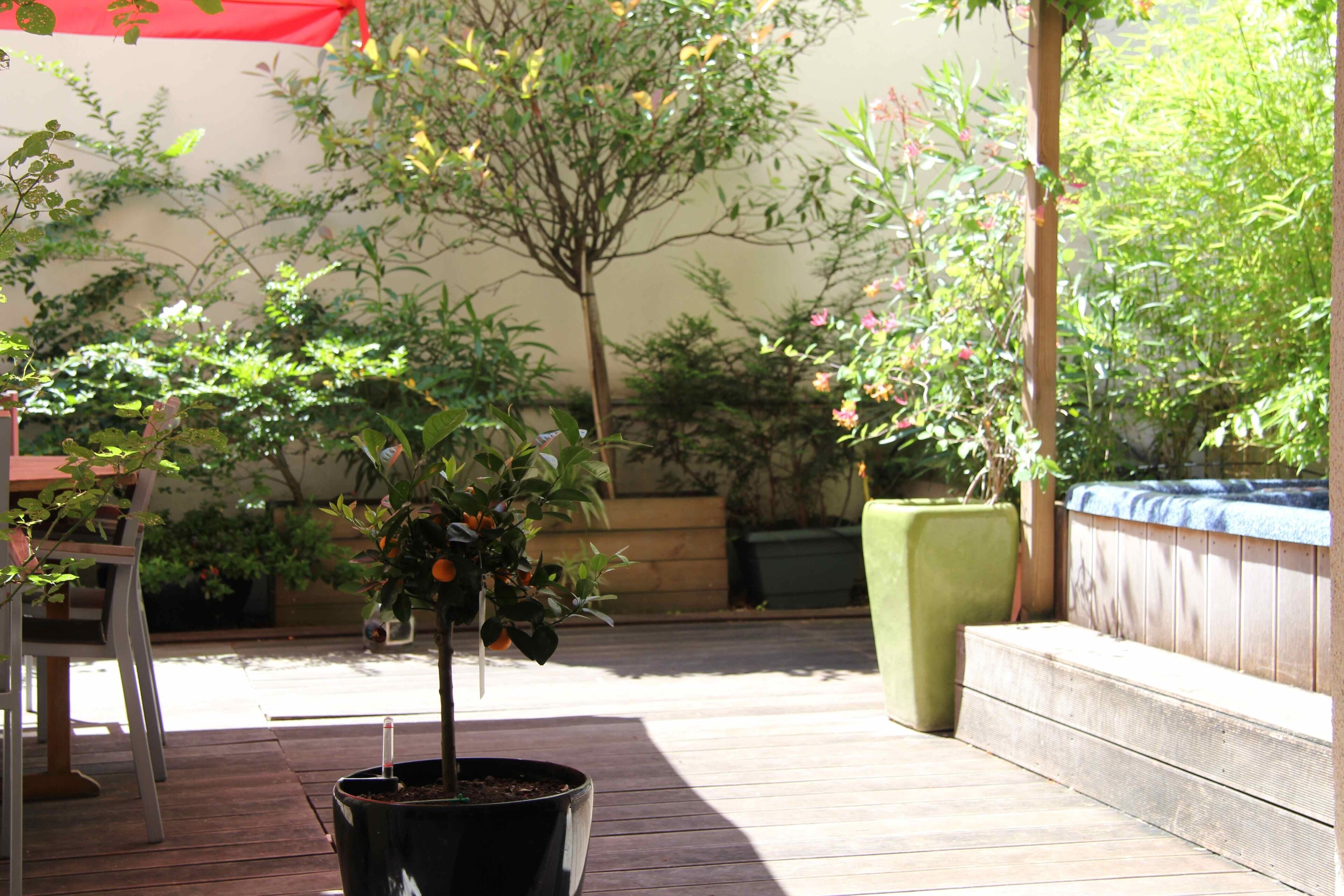 A wooden deck with potted plants and a seating area.