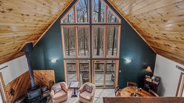 Una cabaña acogedora con un ventanal grande, interior de madera y chimenea.