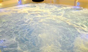 A hot tub with visible bubbles and water movement. - Sqyrls Nest - hot tub, pets, fire pit, game room, grill, wifi, view (Berkeley Springs)