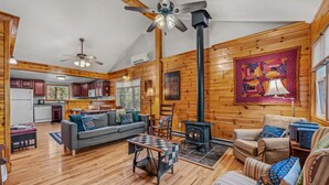 A cozy cabin interior with a living room, kitchen, and dining area.