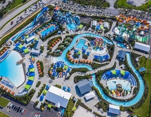 Eine Vogelperspektive eines Wasserparks mit mehreren Schwimmbecken, Wasserrutschen und Wellenbecken.