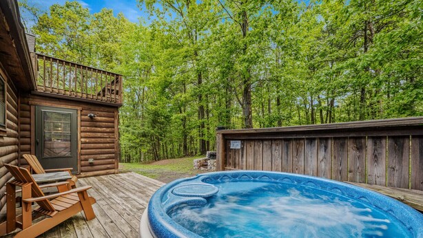 Une cabane en bois avec un jacuzzi et des chaises longues.