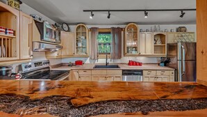 Une cuisine moderne avec des meubles en bois, des appareils électroménagers en acier inoxydable et un îlot central.