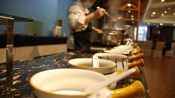 A row of white bowls with yellow handles on a counter.