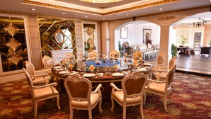 A formal dining room with a round table set for a meal, surrounded by ornate chairs. - Yantai Asia Hotel (Yantai)