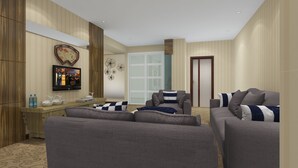 A modern living room with grey sofas, a wooden cabinet, a flat-screen TV, and decorative wall art.