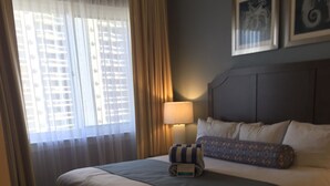 Ein Hotelzimmer mit einem großen Bett, einer Nachttischlampe und zwei gerahmten Bildern an der Wand.