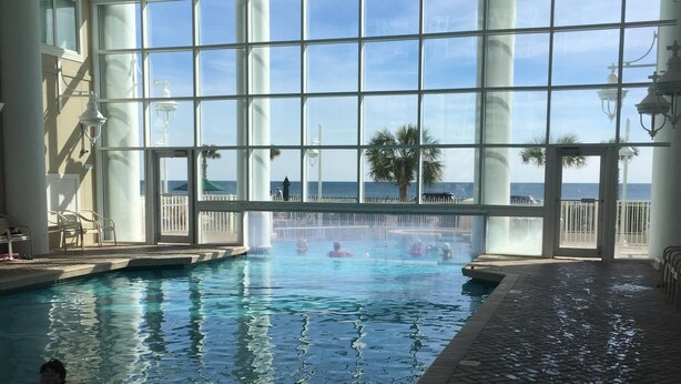 Ein Innenpool mit freiem Blick auf das Meer durch große Fenster.