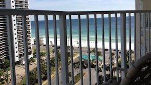 Ein Balkon mit Blick auf einen Strand und einen Parkplatz.