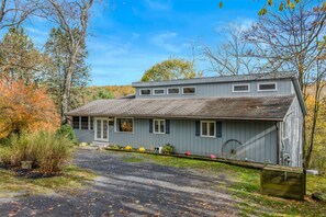 A two-story house with a front porch, a garage, and a driveway. - Serendipity - Hot Tub | Pets | Fire Pit | Pool Access | Grill | Wifi | Deck (Berkeley Springs)