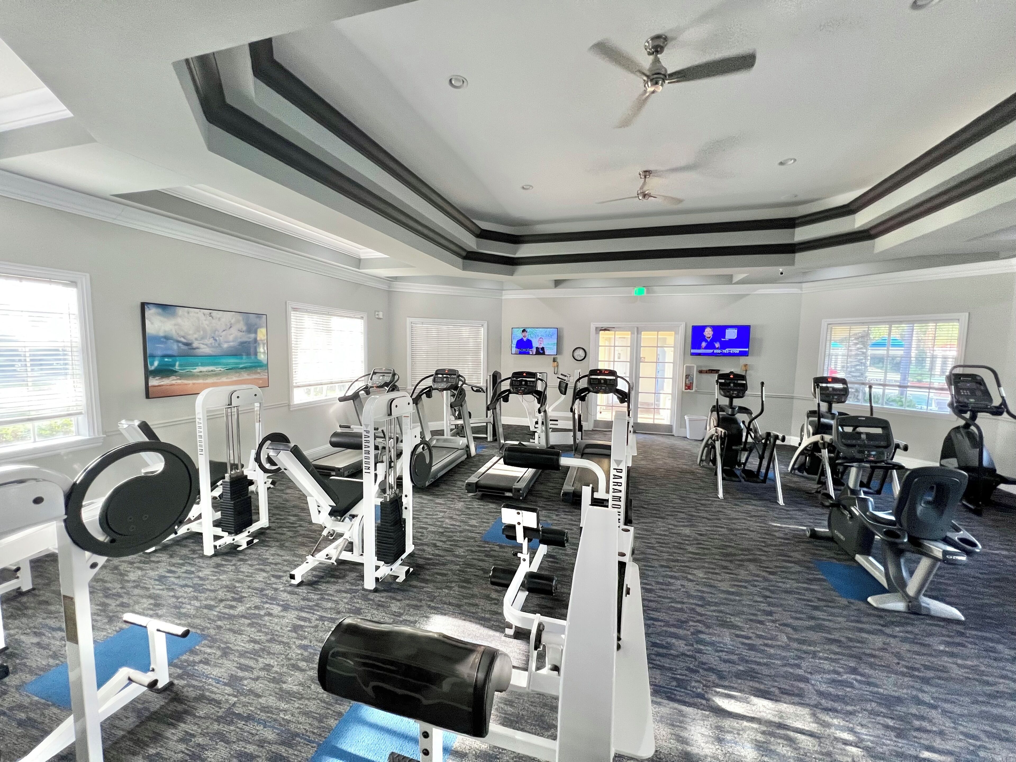 Une salle de sport équipée de tapis de course, de vélos elliptiques et de matériel de musculation.