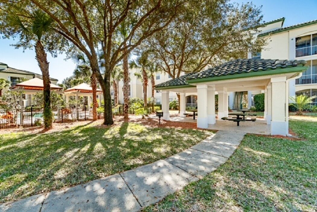 A covered outdoor area with picnic tables and a pathway.