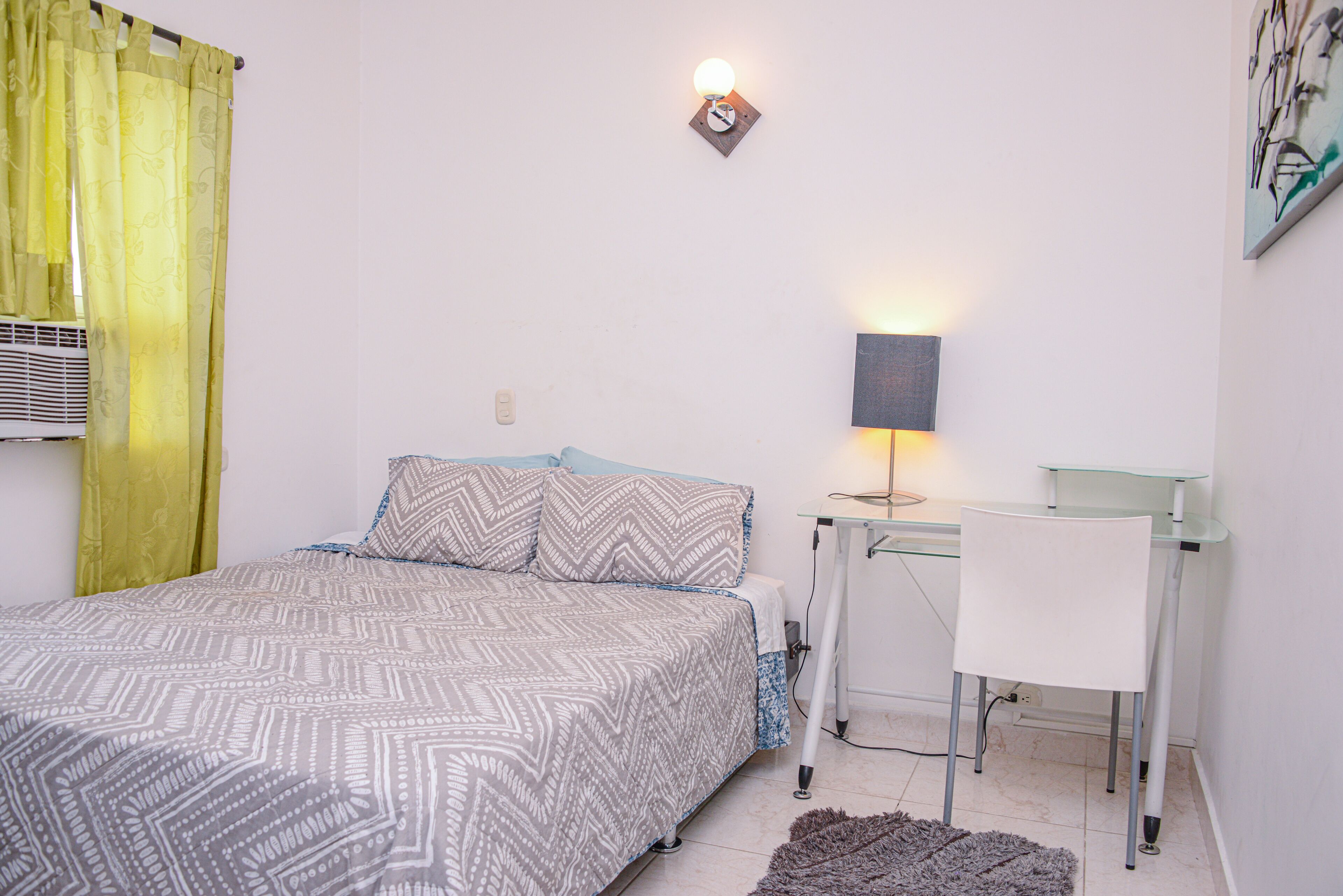 Ein Schlafzimmer mit einem Bett, einem Schreibtisch und einem Stuhl.