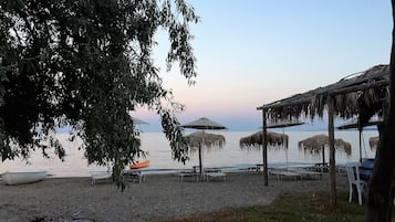 Una playa cerca, sillas reclinables de playa, toallas de playa