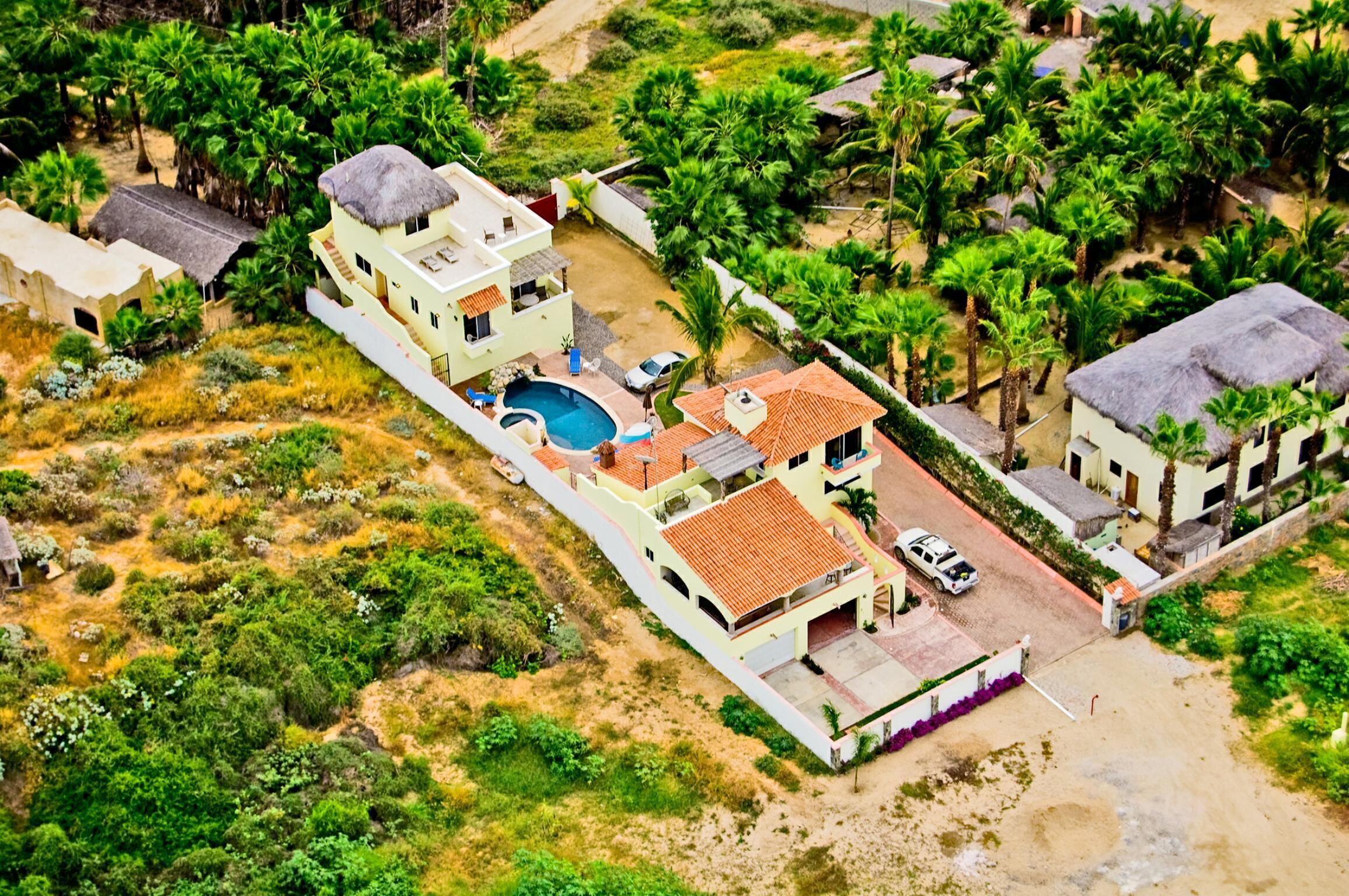 Vista aérea de una zona residencial con casas, piscina y vegetación circundante.