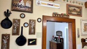 A kitchen with a rustic decor, including a welcome sign, a 'home sweet home' sign, and various kitchen utensils and decorations. - The Farmhouse reopens after an upgrade on the second floor!   (South Bend)