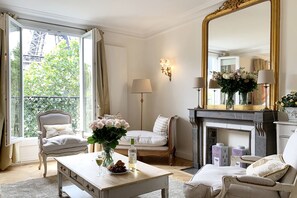 A well-lit room with a large mirror, a fireplace, and a view of greenery outside.