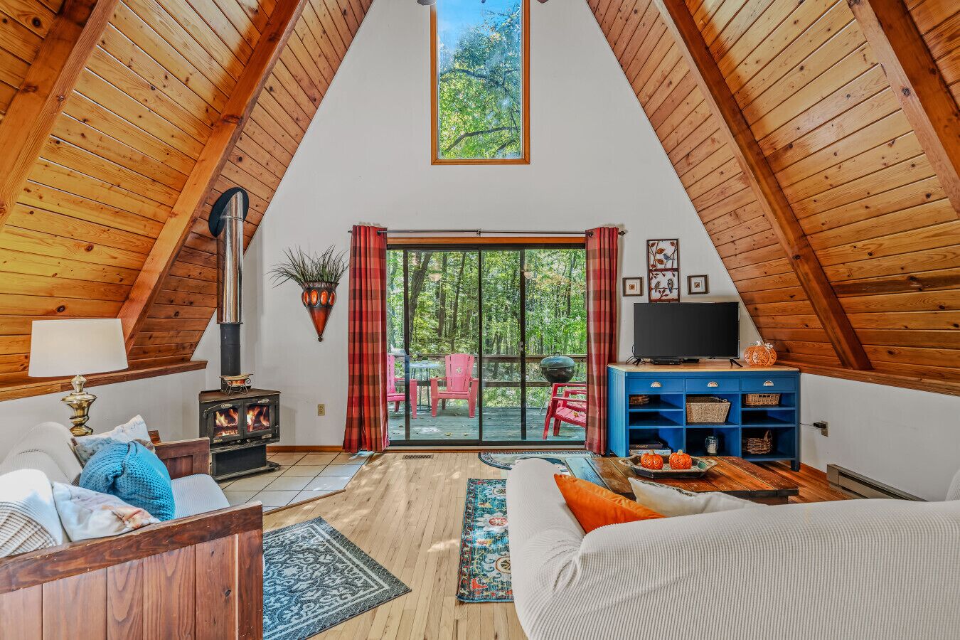 An attic room with a fireplace, a television, and a large sliding glass door leading to an outdoor area.