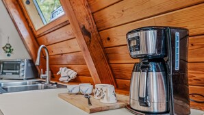 Eine Küche mit Kaffeemaschine, Toaster und einem Holzschneidebrett mit Tassen.