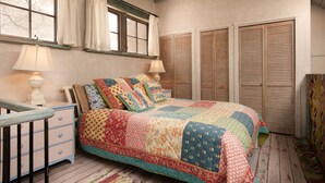 A bedroom with a bed, two bedside tables, a window with curtains, and wooden shutters. - Spacious, Sunlit Adobe Casita #6 / B&B in the Heart of Historic Taos! (Taos)