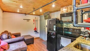A compact kitchen with a refrigerator, stove, and microwave.