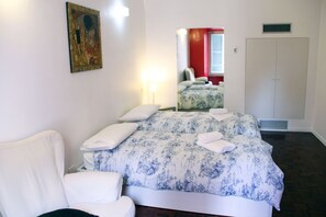 Relax in comfort with a large bed, a stylish armchair, and a wardrobe for your belongings.