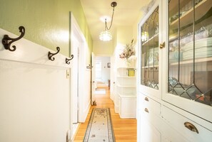Stylish hallway with a patterned rug and a cabinet with glass doors.