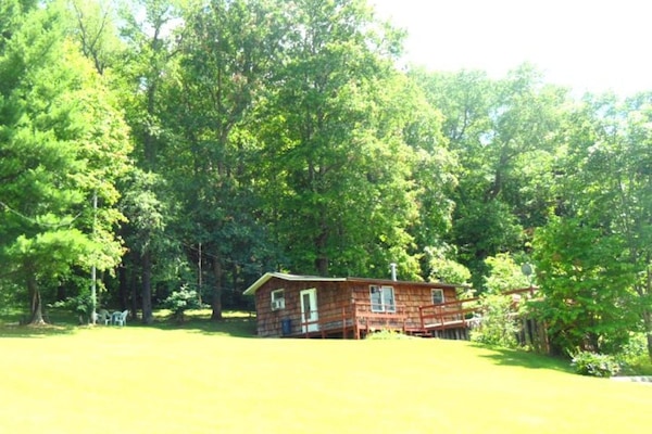 Summer view of this cozy cabin by the woods. Rural, yet so near to attractions.