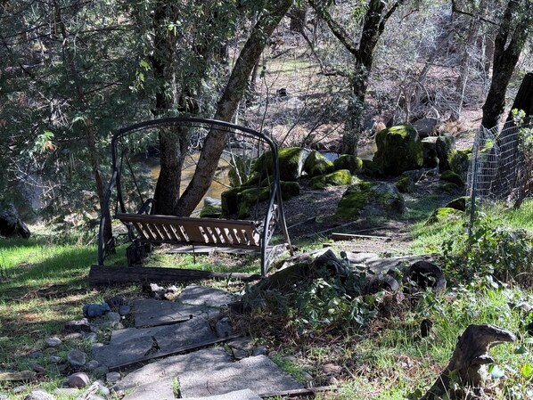 Un banco en un área boscosa con un sendero y rocas.