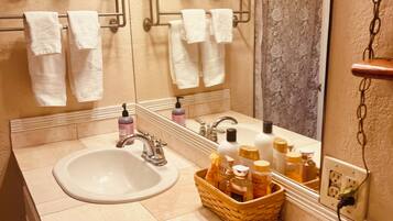 Een bad/douchecombinatie, een haardroger, handdoeken, zeep