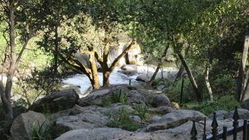 A natural landscape with a river, rocks, and trees.