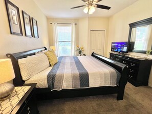 A bedroom with a bed, a TV, a dresser, and a ceiling fan. - 9-104 Legacy Dunes, Close to Disney, Heated Pool, Free Wifi & Parking (Kissimmee)