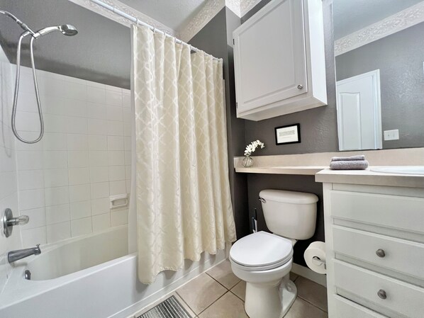 Un baño con bañera, inodoro y ducha.