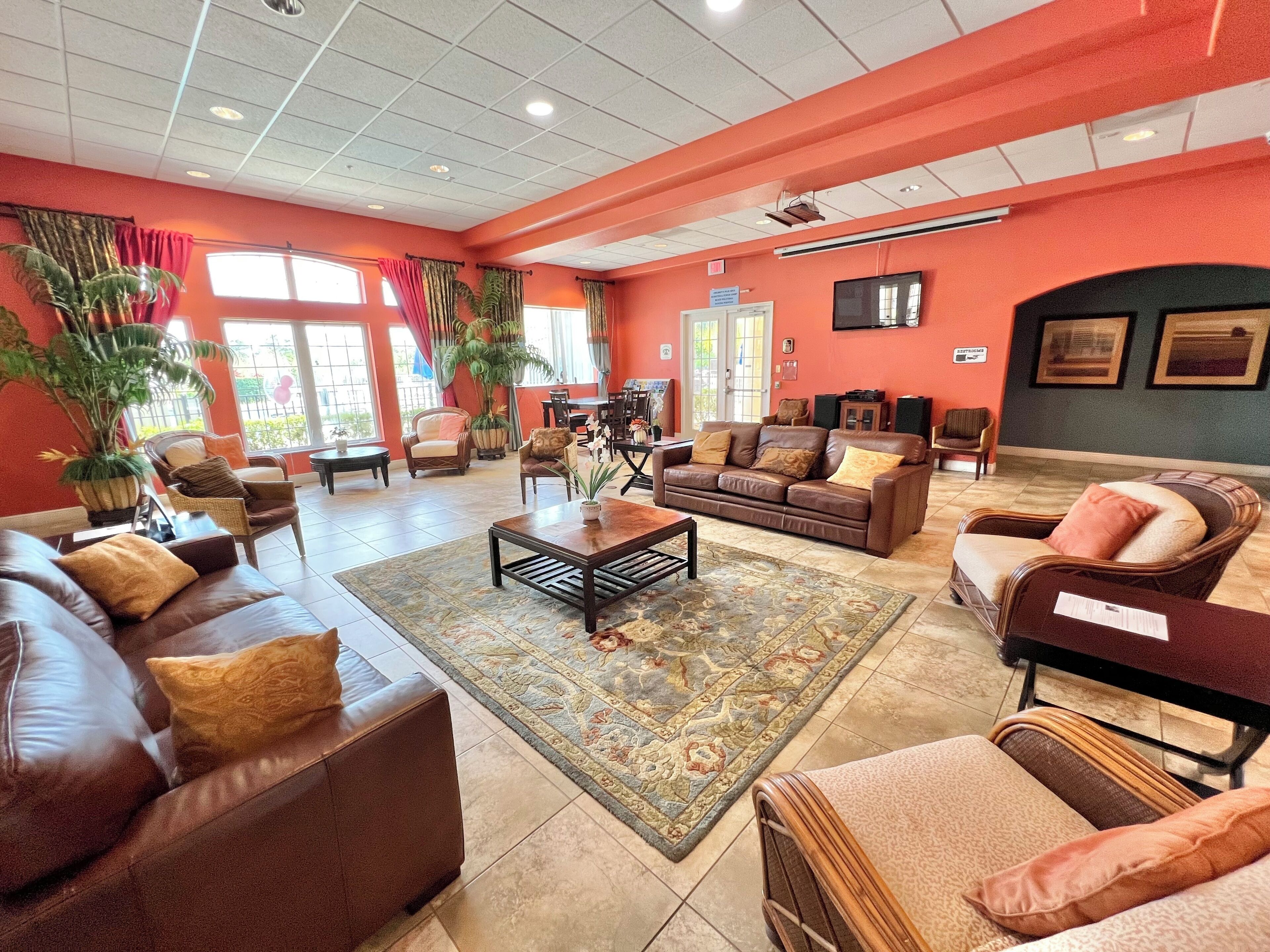 A spacious lobby with leather sofas, a coffee table, and potted plants.