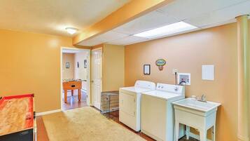 A laundry area with a washing machine, dryer, and a sink.