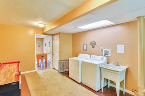 A laundry area with a washing machine, dryer, and a sink.