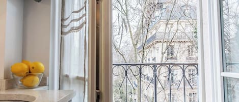 Eine Küche mit einer Zitronenschale auf der Arbeitsplatte, ein Fenster mit Blick auf ein Gebäude und Bäume.