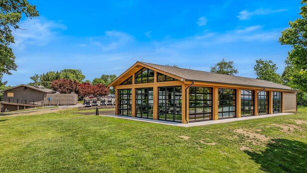 Un bâtiment moderne doté d’une grande façade en verre et d’un toit en bois.