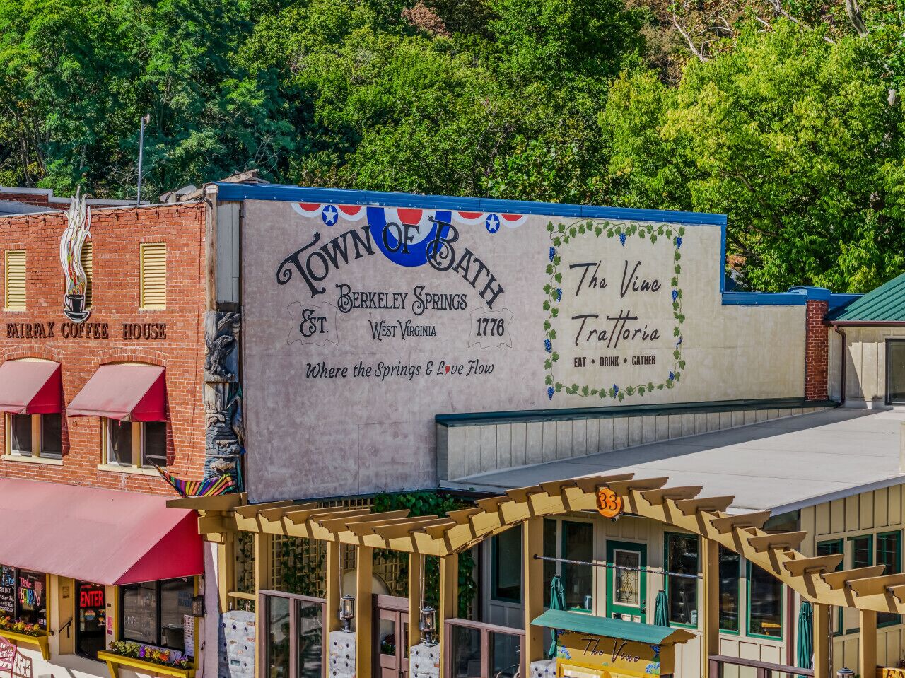 A building with a sign reading "Town of Bath Berkeley Springs West Virginia 1776" and "The Vine Tavernoria".