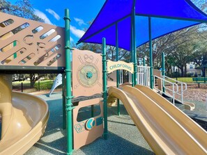 A playground with two slides, a blue canopy, and a sign reading "CHILDFORMS".