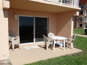 Enjoy al fresco dining and socializing in this outdoor space with a sliding glass door and comfortable seating for small gatherings.