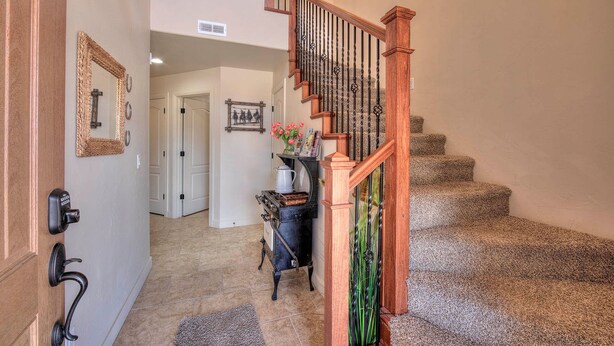 A staircase with wooden railings and a carpeted landing area. - DW6  Private Hot Tub, En-Suite Bathroom for Each Bedroom, Near Arches Park! (Moab)