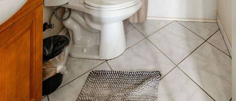 A bathroom with a toilet, bidet, bathtub, and a shower curtain.