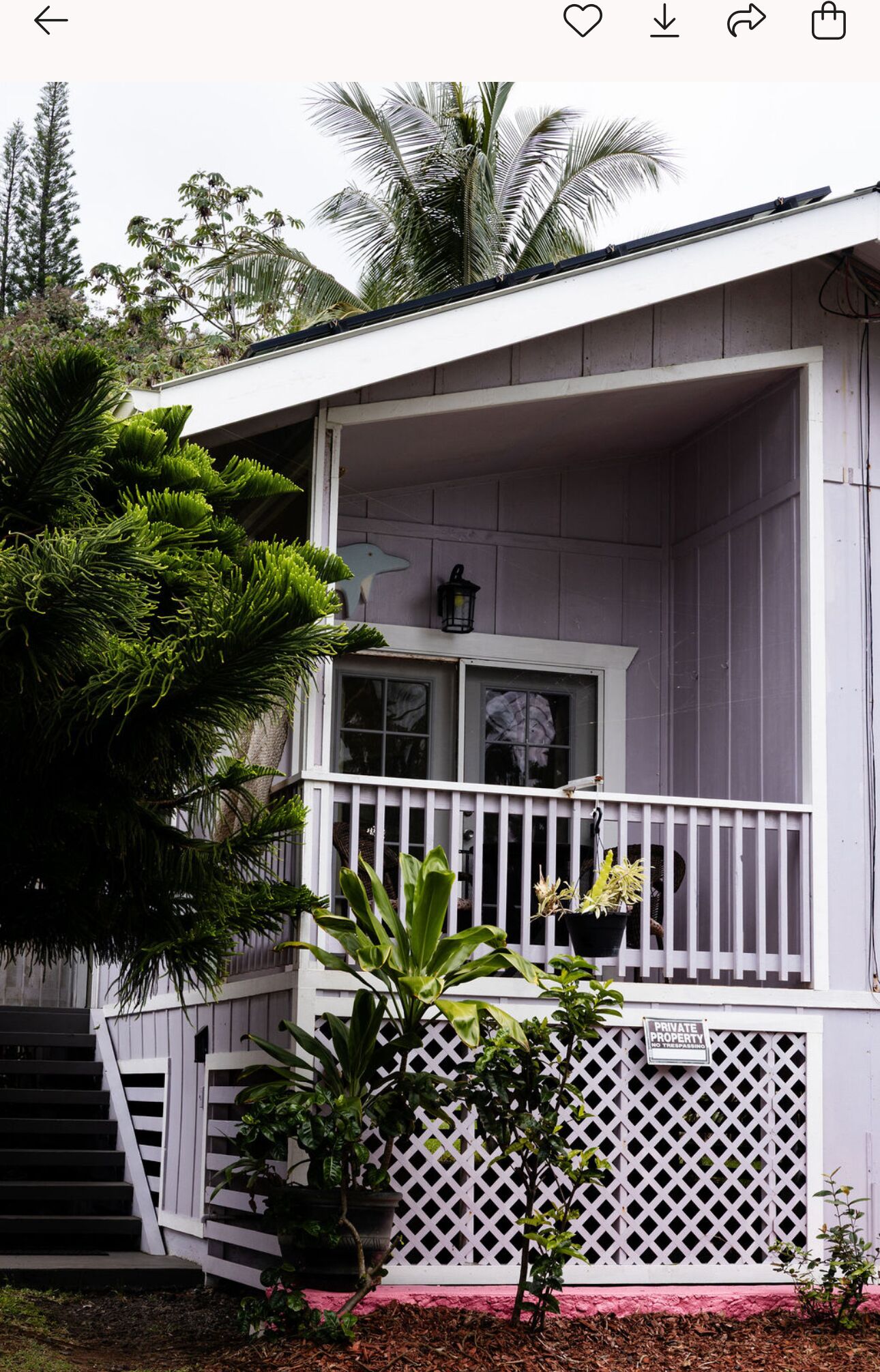 A white two-story house with a balcony, a small porch, and a 'PRIVATE PROPERTY NO TRESPASSING' sign.