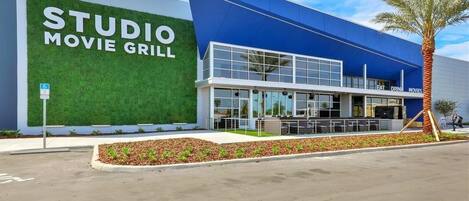 A modern building with a sign reading "STUDIO MOVIE GRILL."