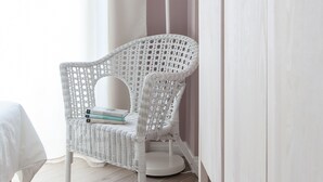 A room with a white wicker chair, a white floor lamp, and a white wardrobe. - Pannonia Smart House (Rome)