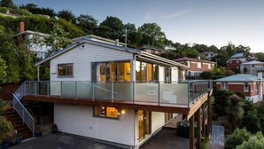 A two-story house with a balcony, a garage, and a driveway. - Baldwin Street BNB (Dunedin)