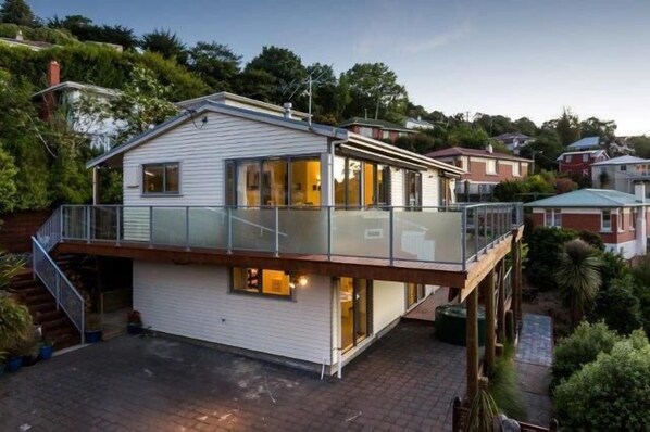 A two-story house with a balcony, a garage, and a driveway.